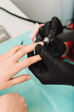 Manikürcü, manikür manikürcüsü. Manikür işlemi. Beaty Stüdyoları 'nda manikür sürecinin yakın çekimi..