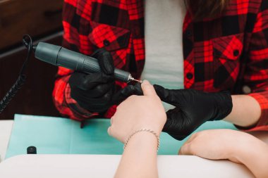 Manikürcü, manikür manikürcüsü. Manikür işlemi. Beaty Stüdyoları 'nda manikür sürecinin yakın çekimi..