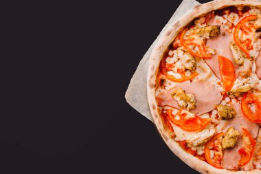 Lezzetli biberli pizza ve siyah beton arka planda domates fesleğeni. Acı biberli pizza..