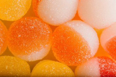Makro fotoğraf, çok renkli marmelatlı jöle şekeri. Limon ve portakal dilimleri şeklinde tatlı marmeladı. Jöleli şekerin tatlılığı sarı ve turuncu.