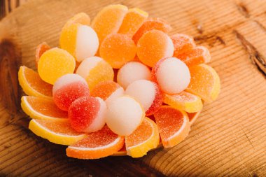 Makro fotoğraf, çok renkli marmelatlı jöle şekeri. Limon ve portakal dilimleri şeklinde tatlı marmeladı. Jöleli şekerin tatlılığı sarı ve turuncu.