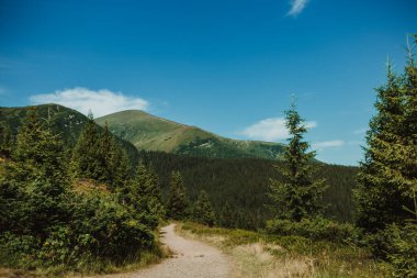 Dağ yolu en yüksek dağlara çıkıyor. Spor ve aktif yaşam konsepti. Güzel manzara. Mavi gökyüzü