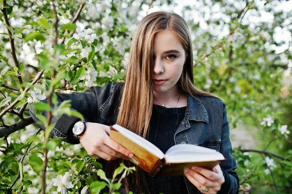 Genç Esmer Kız Kot Bahar Çiçeği Ağacına Kitap Okumak — Stok fotoğraf
