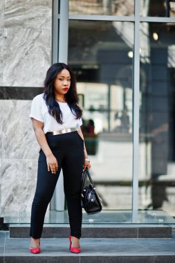 Şık Afro-Amerikan iş kadını ile şehir sokaklarında el çantası.