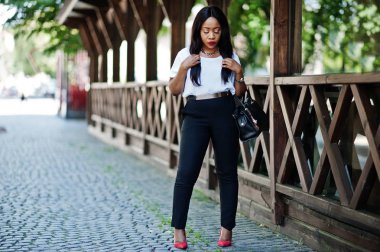 Şık Afro-Amerikan iş kadını ile şehir sokaklarında el çantası.