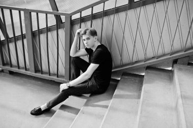 Siyah ceketli genç şık maço çocuk Sokağı'nın açık poz verdi. İnanılmaz modeli adama kırmızı merdiven tonnel.