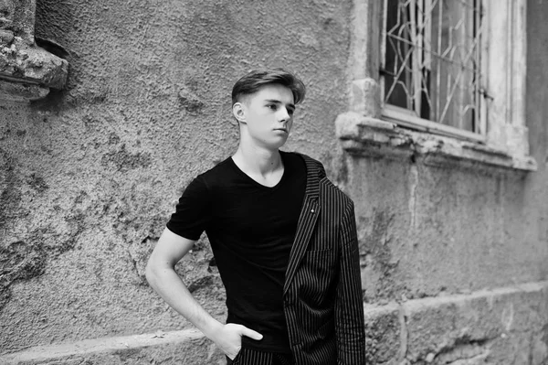 黒のジャケットでスタイリッシュなマッチョ少年を通りの屋外提起しました 素晴らしいモデル男 — ストック写真