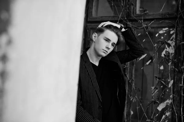 黒のジャケットでスタイリッシュなマッチョ少年を通りの屋外提起しました 素晴らしいモデル男 — ストック写真
