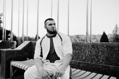 Kaslı erkek giyimi kırmızı gömlek ile beyaz spor takımı üzerinde acımasız Genç sakallı.