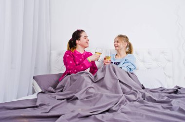 İki arkadaş kızlar yatak odasında eğleniyor pijama.