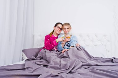 İki arkadaş kızlar yatak odasında eğleniyor pijama.