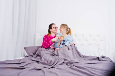İki arkadaş kızlar yatak odasında eğleniyor pijama.