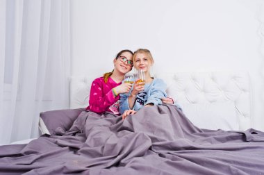 İki arkadaş kızlar yatak odasında eğleniyor pijama.
