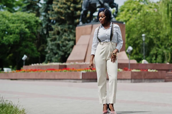 Şık Afro-Amerikan iş kadın pantolon askı ve bluz ile açık poz verdi.