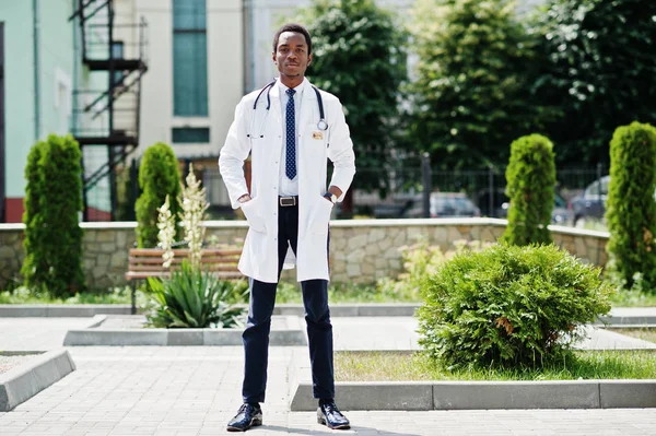 Şık Afrikalı-Amerikalı doktor stetoskop ve laboratuvar ceket ile hastane arka poz verdi..
