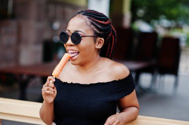 Güneş gözlüğü dondurma ile şık Afrikalı-Amerikalı kadın.