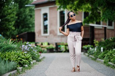 Şık Afrikalı-Amerikalı kadın güneş gözlüğü, açık poz verdi.