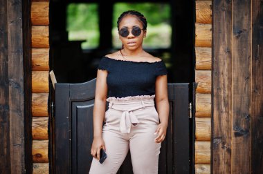 Şık Afrikalı-Amerikalı kadın güneş gözlüğü, açık poz verdi.