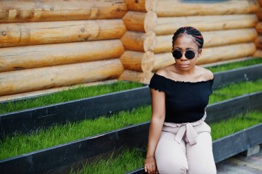 Şık Afrikalı-Amerikalı kadın güneş gözlüğü, açık poz verdi.