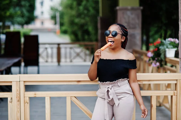 Güneş gözlüğü dondurma ile şık Afrikalı-Amerikalı kadın.