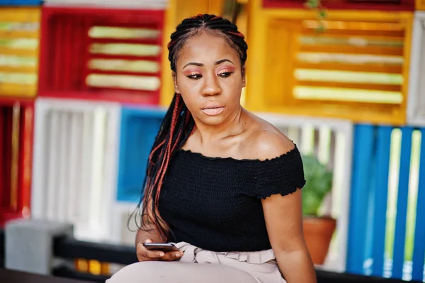 Şık Afrikalı-Amerikalı kadın açık ve kullanma cep telefonu poz verdi..