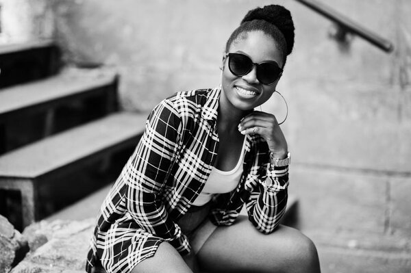 Hip hop african american girl on sunglasses and jeans shorts. Casual street fashion portrait of black woman.