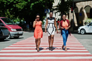 Üç şık Afrikalı-Amerikalı kadının yürüme yaya geçidi veya yaya geçidi, birbirimizi konuşan ve having fun.