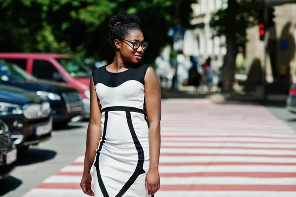 Yaya geçidi veya yaya geçidi üzerinde yürüyen şık Afrikalı-Amerikalı kadın.