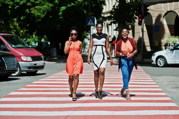 Üç şık Afrikalı-Amerikalı kadının yürüme yaya geçidi veya yaya geçidi, birbirimizi konuşan ve having fun.