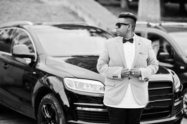 Şık bir ceket, papyon ve güneş gözlüğü siyah suv araba karşı Arap adam. Arap zengin işadamı. 