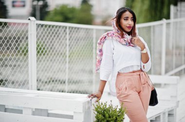 Beyaz bluz ve şeftali pantolon Arap kız moda açık poz verdi. Şık Müslüman kadın.