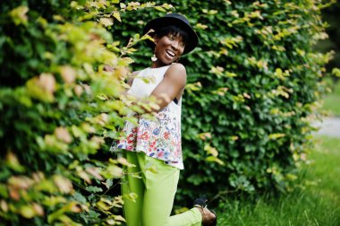 Yeşil pantolon ve siyah şapka Parkı'nda yarattığı inanılmaz bir Afro-Amerikan modeli kadın.