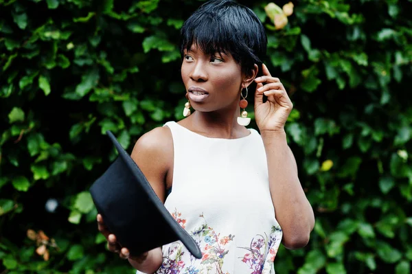 İnanılmaz bir Afro-Amerikan modeli kadın yeşil pantolon ve siyah şapka Park'ta farklı duygular ile poz verdi. 