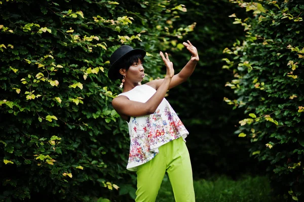 Yeşil pantolon ve siyah şapka Parkı'nda yarattığı inanılmaz bir Afro-Amerikan modeli kadın.