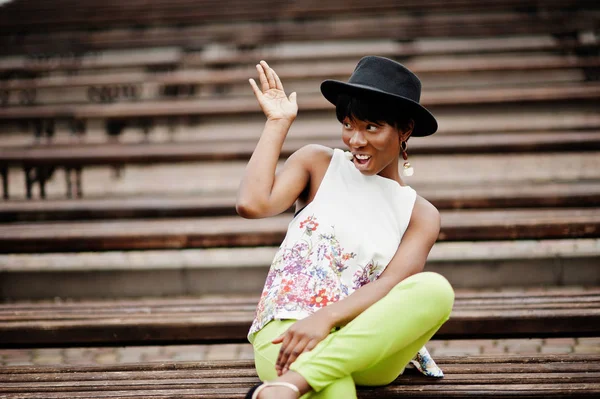 Yeşil pantolon ve siyah şapka tezgah yarattığı inanılmaz bir Afro-Amerikan modeli kadın.