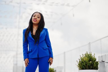 Başarı Afro-Amerikan iş kadını cep telefonu ile mavi takım elbise. 