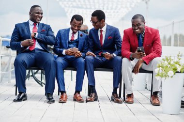 Grup dört Afro-Amerikan mutlu başarılı takım mans. Zengin siyah iş vasıl hareket eden telefon arıyorum koltukları oturan adamın.