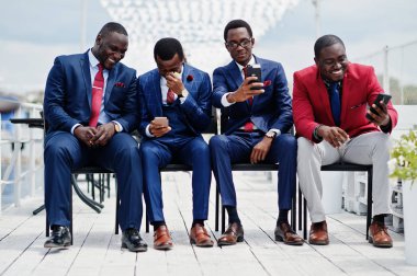 Grup dört Afro-Amerikan mutlu başarılı takım mans. Zengin siyah iş vasıl hareket eden telefon arıyorum koltukları oturan adamın.