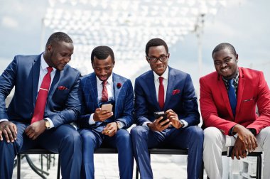 Grup dört Afro-Amerikan mutlu başarılı takım mans. Zengin siyah iş vasıl hareket eden telefon arıyorum koltukları oturan adamın.
