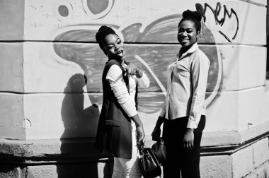 İki şık Afro-Amerikan Kız arkadaş çanta ile steets City açık poz verdi.