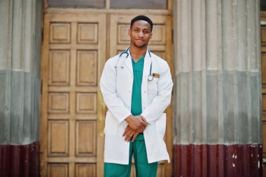 Afrika kökenli Amerikalı doktor erkek önlük stetoskop klinik kapı karşı açık ile.