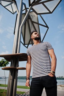 Yakışıklı uzun boylu Arap sakal man modeli soyulmuş gömlek, güneş paneli karşı açık poz verdi. Moda Arap adam. 