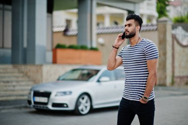 Yakışıklı uzun boylu Arap sakal man modeli soyulmuş gömlek, araba karşı açık poz verdi. Moda Arap adam. Müslüman işadamı cep telefonu konuşma.
