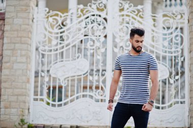 Yakışıklı uzun boylu Arap sakal man modeli soyulmuş gömlek, Kraliyet demir kapıları karşı açık poz verdi. Moda Arap adam. 