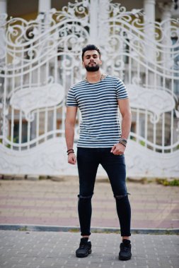 Yakışıklı uzun boylu Arap sakal man modeli soyulmuş gömlek, Kraliyet demir kapıları karşı açık poz verdi. Moda Arap adam. 