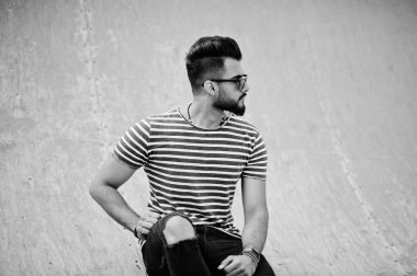 Yakışıklı uzun boylu Arap sakal man modeli soyulmuş gömlek, açık poz verdi. Güneş gözlüğü moda Arap adama.