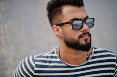 Yakışıklı uzun boylu Arap sakal man modeli soyulmuş gömlek, açık poz verdi. Güneş gözlüğü moda Arap adama.