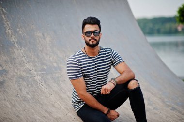 Yakışıklı uzun boylu Arap sakal man modeli soyulmuş gömlek, açık poz verdi. Güneş gözlüğü moda Arap adama.
