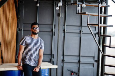 Yakışıklı uzun boylu Arap sakal man modeli soyulmuş gömlek, açık poz verdi. Güneş gözlüğü moda Arap adama.
