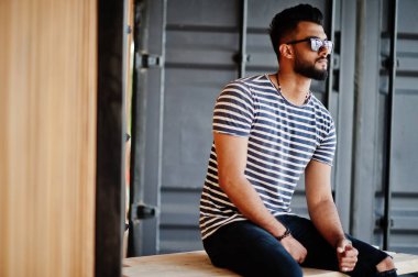 Yakışıklı uzun boylu Arap sakal man modeli soyulmuş gömlek, açık poz verdi. Güneş gözlüğü moda Arap adama.